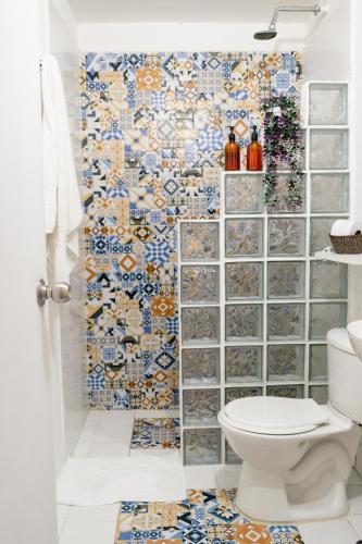 a bathroom with a toilet and a wall of tiles at Casa Guerrero in Cartagena de Indias