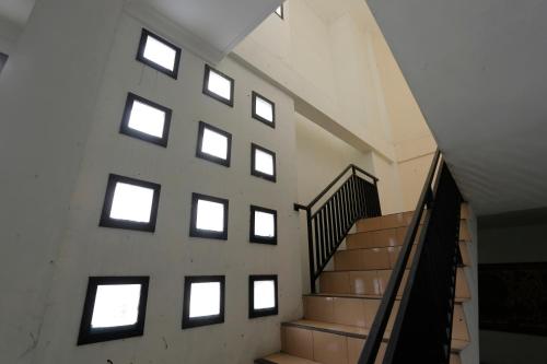 a staircase in a building with a bunch of windows at Hotel O Rumah Kost Kita Tarakan in Tarakan