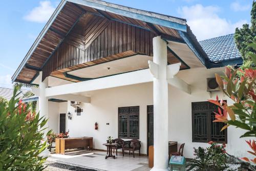 a house with a wooden roof at Hotel O Wisma Pundu Syariah Near Kantor Camat Kota Besi in Kotabesi