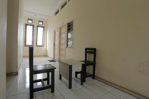 a room with a table and a chair and a window at Hotel O Rumah Kost Kita Tarakan in Tarakan