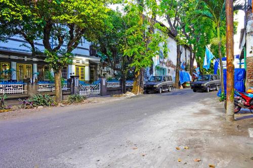 a street with cars parked on the side of the road at Hotel O Homestay Barokah in Gresik