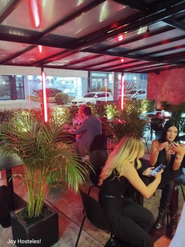 a woman sitting at a table in a restaurant at Hostel Joy Calle 85 in Bogotá