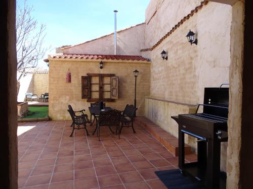 a patio with a piano and a table and chairs at Casa Rural El Breval in Alcazarén