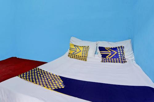 a bed with four pillows on top of it at Hotel O Lestari Syariah in Sidoarjo