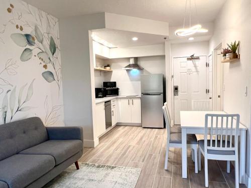 a living room with a couch and a table and a kitchen at Condo close to Epic Universe - free parking in Orlando