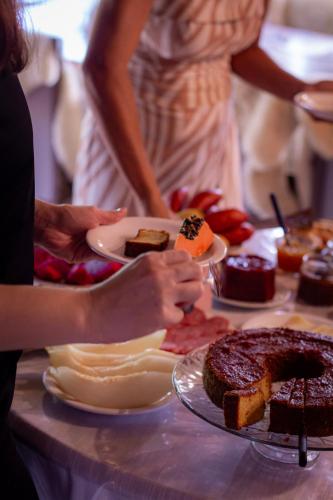 a table topped with plates of food and desserts at Figueira do Rio do Boi Com Hidromassagem in Praia Grande