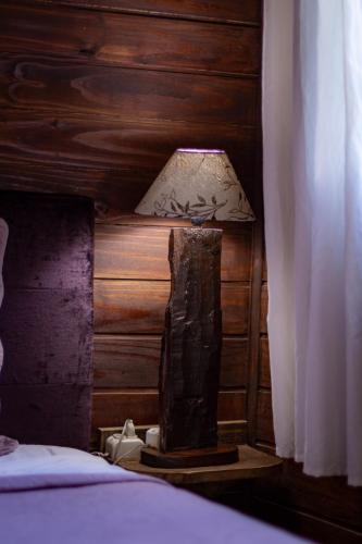 a lamp sitting on a table next to a bed at Figueira do Rio do Boi Com Hidromassagem in Praia Grande