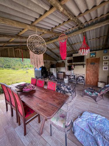 a wooden table and chairs in a living room at Figueira do Rio do Boi Com Hidromassagem in Praia Grande