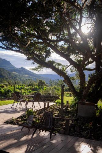a group of chairs sitting under a tree at Figueira do Rio do Boi Com Hidromassagem in Praia Grande
