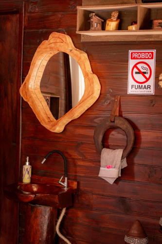 a bathroom with a wooden wall with a mirror and a sink at Figueira do Rio do Boi Com Hidromassagem in Praia Grande