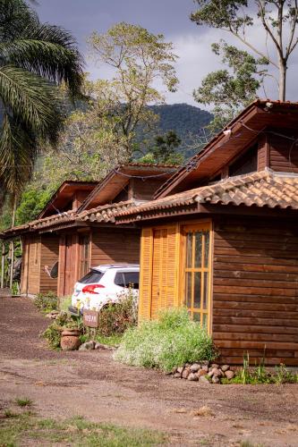 a house with a car parked in front of it at Figueira do Rio do Boi Com Hidromassagem in Praia Grande