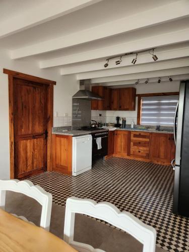 a kitchen with wooden cabinets and white appliances at Viña Le Vigneron in Población