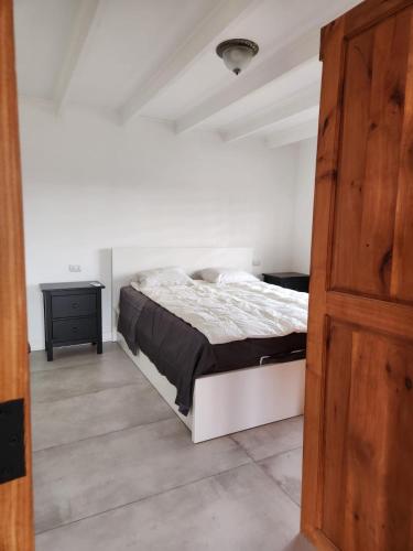 a bedroom with a bed and a wooden door at Viña Le Vigneron in Población