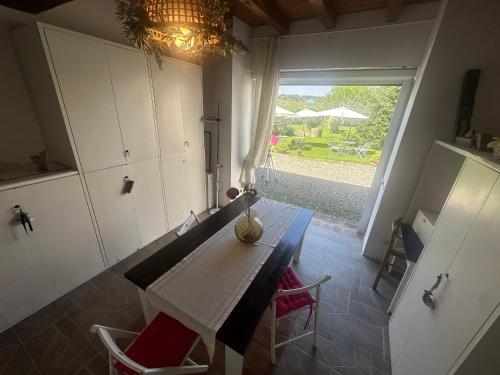 a kitchen with a table and a large window at Nido nel Verde in Arena Po