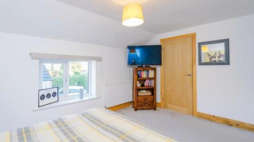 a bedroom with a bed and a window and a door at Oswaldtwistle Farmhouse in Oswaldtwistle