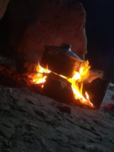 a pot on fire in a fireplace at night at Petra candles studios in Petra