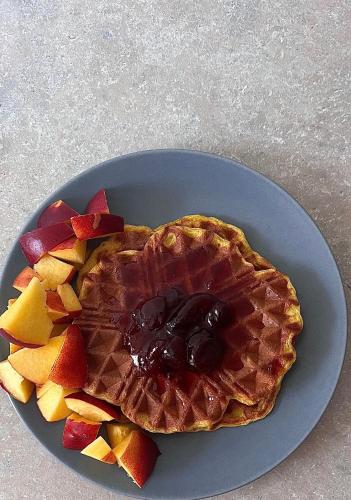 une gaufrette et des fruits sur une plaque bleue dans l'établissement The Loraine Luxury Suites, à Witbank