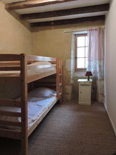 une chambre avec deux lits superposés et une fenêtre dans l'établissement Saint Aignan Gîte 12 people, à Pillac