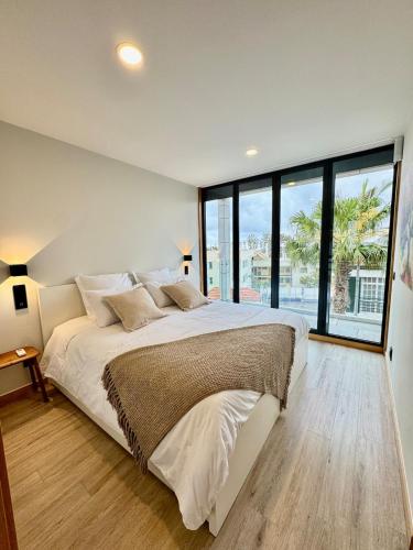 a bedroom with a large bed and a large window at Square house in Funchal