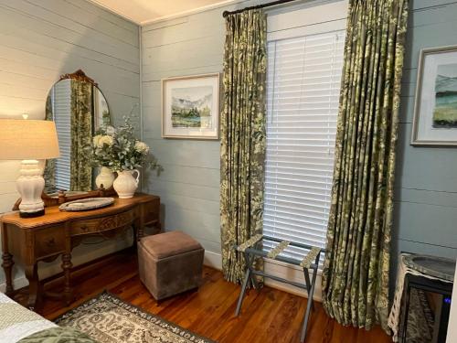 a room with a desk and a window with curtains at Yellow Daisy Bed and Breakfast in Dahlonega