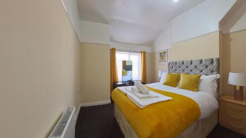 a bedroom with a large bed with a yellow blanket at Havana Lodge in Elswick