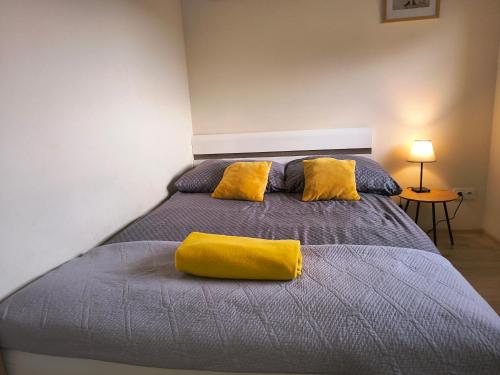 a bedroom with a bed with a yellow pillow on it at Apartament ZARA Self Check In in Rzeszów