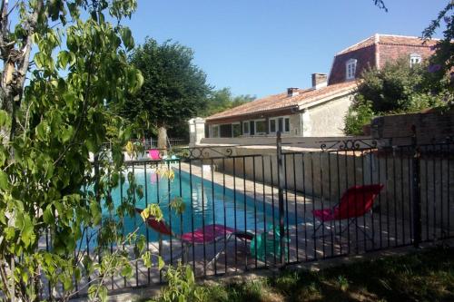 - une piscine avec 2 chaises à côté d'une clôture dans l'établissement Le Four et l'Alambic Gîtes, à Pillac