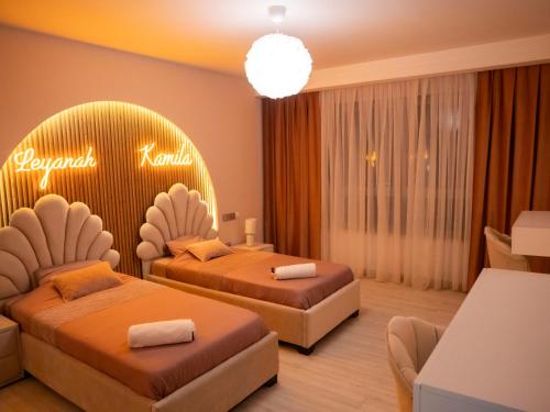 a hotel room with two beds and a sign on the wall at Appartement Haut Standing Mobilart Oran in Oran
