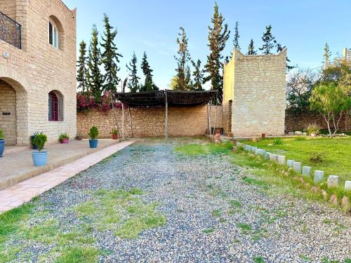 a courtyard of a brick building with a yard at QUIET OASIS Luxury Stone Villa with Panoramic Views near Essaouira in Essaouira