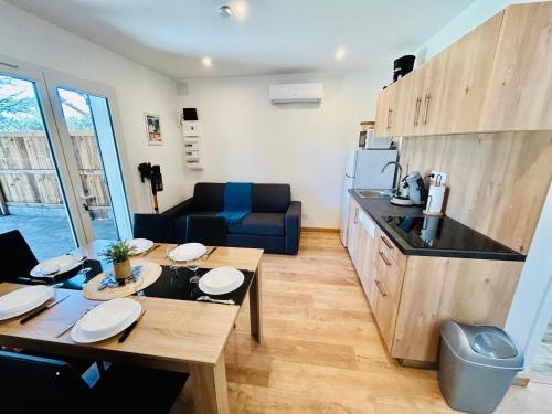 d'une cuisine et d'un salon avec une table en bois et un sidx de table. dans l'établissement Escale des grands lacs, à Gastes