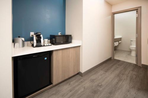 a kitchen with a microwave on a counter with a toilet at Holiday Inn Express & Suites Indianapolis - East by IHG in Indianapolis