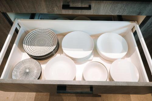 a drawer filled with white plates and a fan at Grand appartement rez de jardin in Guebwiller