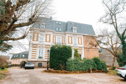 a large house with a car parked in front of it at Grand appartement rez de jardin in Guebwiller
