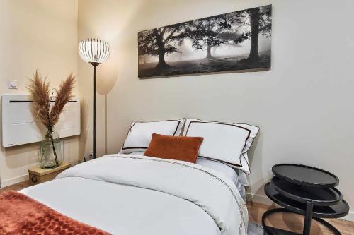 une chambre avec un lit blanc et une chaise dans l'établissement Cozy Confort, à Villeurbanne