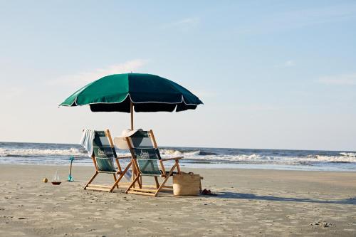two chairs and an umbrella on a beach at Shipwatch 321D by Wild Dunes, Oceanfront Condo in Isle of Palms