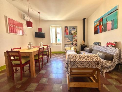 een woonkamer met een tafel en een bank bij Nura's - Il Balcone sui Tetti in Alghero