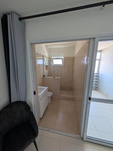 a bathroom with a sliding glass door leading to a toilet at Casa Relaxod in Santa Maria