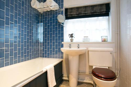 a bathroom with a toilet and a sink and a tub at The Huntsman of Brockenhurst in Brockenhurst