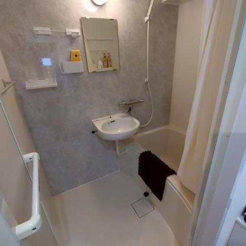 a small bathroom with a sink and a mirror at JR Shin-Osaka 2mins, Direct to Kansai Airport 關西空港直達,Shinkansen to Tokyo, Tokyo & Nagoya, Universal Studio 16 mins, Umeda 6 mins, Kyoto 25 mins, Early Check-In in Osaka