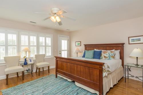 Un dormitorio con una cama y un ventilador de techo. en Grand Pavilion 10 by Wild Dunes, Luxury Home, en Isle of Palms
