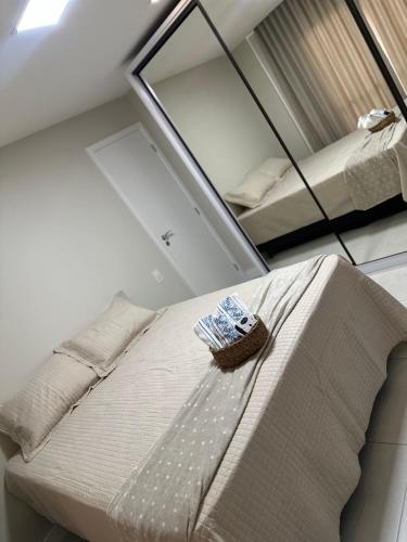 a mirror above a bed in a room at Cobertura Sol Sereno in Cabo Frio