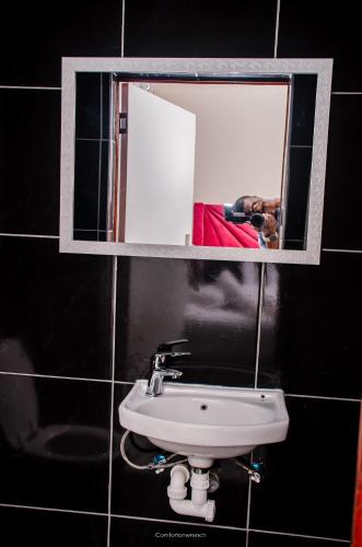 a mirror above a sink in a bathroom at Comfort on Wrench in Cape Town