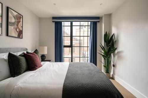a bedroom with a large bed and a window at The Spitalfields Works by Urban Rest in London