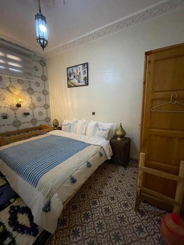 a bedroom with a bed with a blue and white comforter at Gite Marbie maison rurale, une expérience naturelle unique, au coeur du moyen atlas, Maroc in Kasba Tibouda