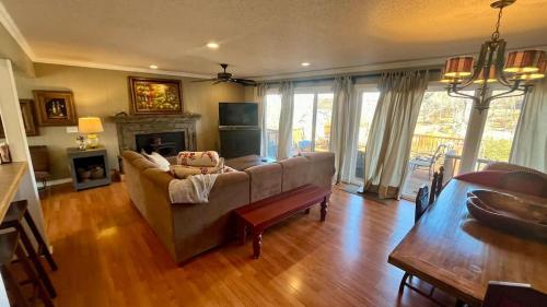 a living room with a couch and a table at Blueberry Bliss Family Retreat on Beaver Lake in Lowell