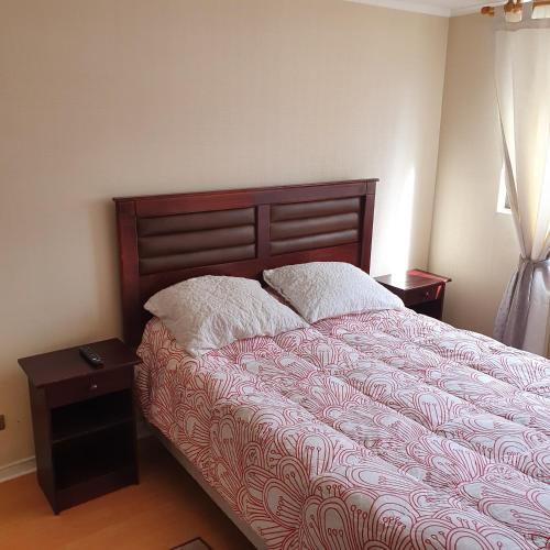a bedroom with a bed with two pillows on it at Departamento Alameda Talca in Talca