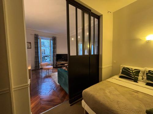 une chambre avec un lit et un grand miroir dans l'établissement Charming Parisian loft near Opera - TF24, à Paris