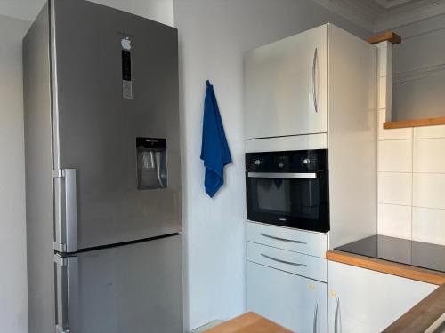 une cuisine avec des appareils en acier inoxydable et des armoires blanches dans l'établissement Charming Parisian loft near Opera - TF24, à Paris