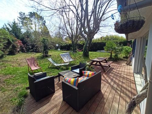 - une terrasse avec 2 chaises, une table et des chaises dans l'établissement Maison landaise avec piscine proche Hossegor Capbreton, à Angresse