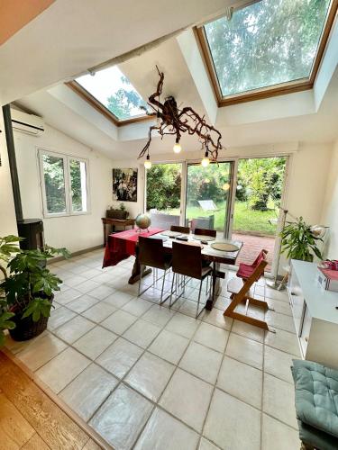 un grand salon avec une table et des chaises dans l'établissement Maison landaise avec piscine proche Hossegor Capbreton, à Angresse